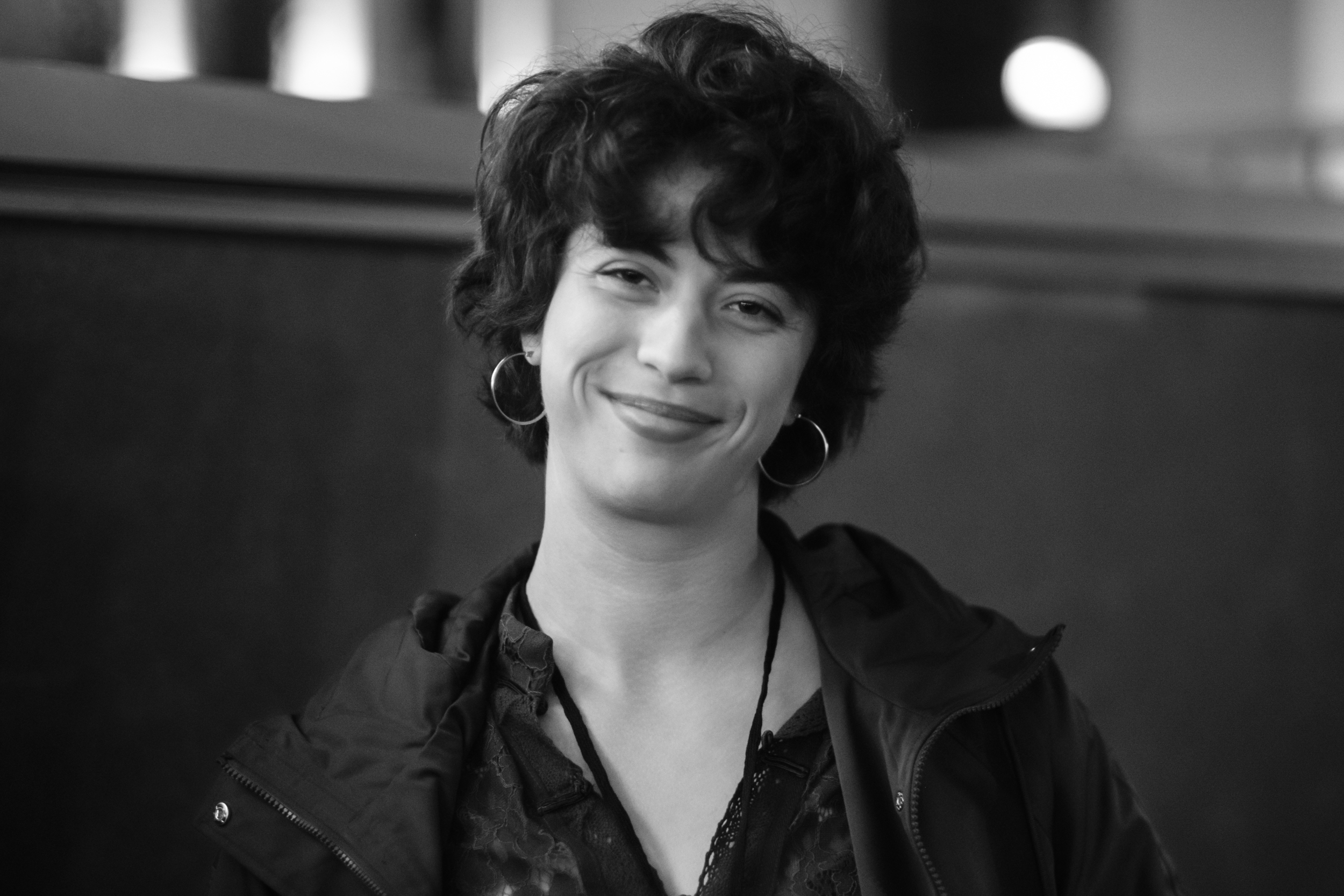 A smiling woman with short dark hair looks toward the camera.