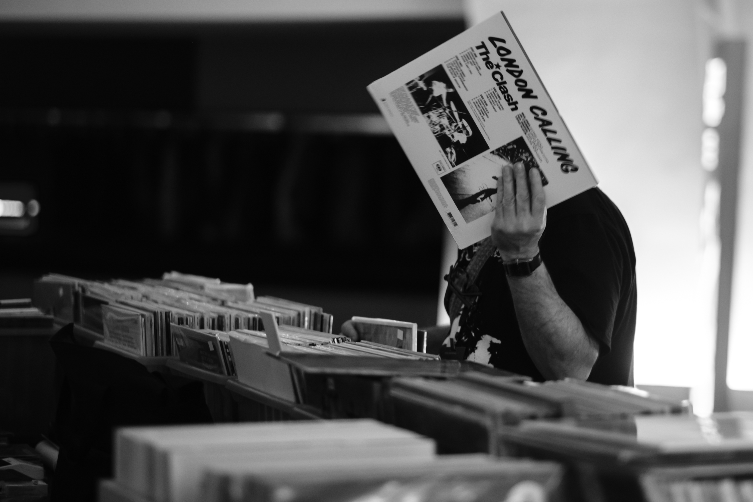 A person at a record stall holds up a record sleeve.
