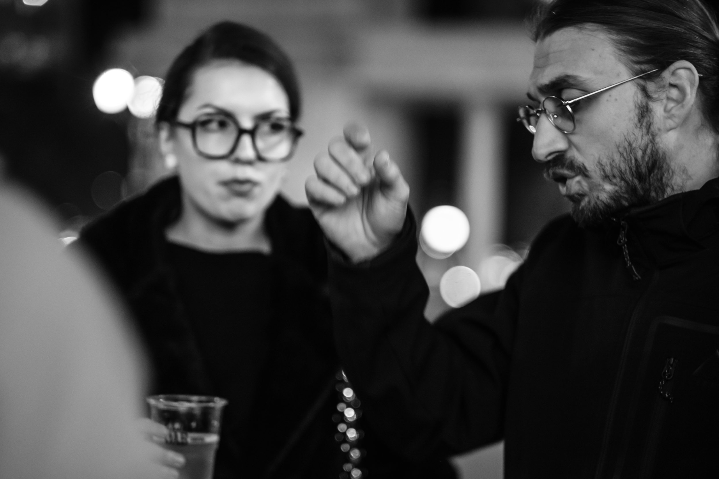 Festival visitors in conversation, one man gesturing with his hand.